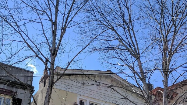 A two-story building with balconies, a yellow facade, and a black car parked in front. - Bright and Airy, Historic Condo on Monterey Square (Savannah)