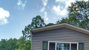 Une maison de plain-pied avec une terrasse à l’avant et une grande fenêtre.