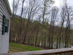 A house with a deck overlooking a forested area and a body of water. - Hide-A-Way Hill with a beautiful view (Hico)