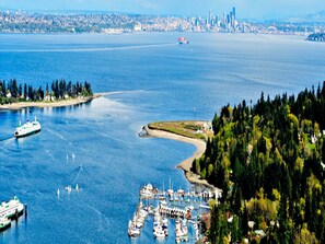 Eine Marina mit vertäuten Booten, ein großes Gewässer und eine ferne Skyline einer Stadt.