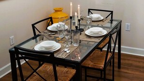 Una mesa de comedor dispuesta con platos, vasos y velas.