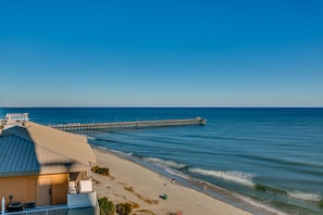 A beachside hotel with a long pier extending into the ocean, a sandy beach, and a clear blue sky. - Spacious Ocean Front  Modern Decor.Spectacular View 2 Full Bath , 2nd floor (Myrtle Beach)