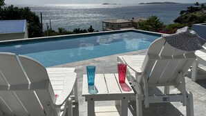 A poolside area with lounge chairs and a view of the ocean. - MANGO MOJO Penthouse Paradise! Stunning Views, Pool, Walk to Cruz Bay, Generator (St John)