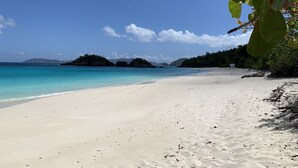A beach with clear turquoise water, white sand, and distant islands. - MANGO MOJO Penthouse Paradise! Stunning Views, Pool, Walk to Cruz Bay, Generator (St John)