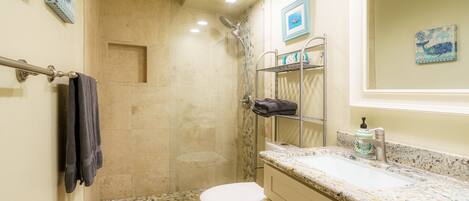 A bathroom with a shower, toilet, and sink.