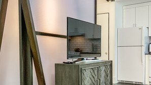 Une cuisine moderne dotée d’un four encastré, d’un réfrigérateur et d’un meuble en bois au motif en chevrons.