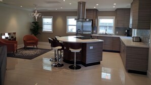 Una cocina moderna con una isla central, electrodomésticos de acero inoxidable y una zona de bar.