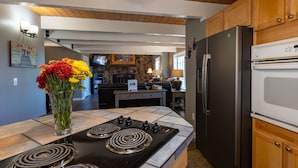A modern kitchen with a gas stove, a refrigerator, and wooden cabinets. - Hot Tub, Hike, Fish, Ride, Eat, Drink or just relax in the Spa (Pagosa Springs)