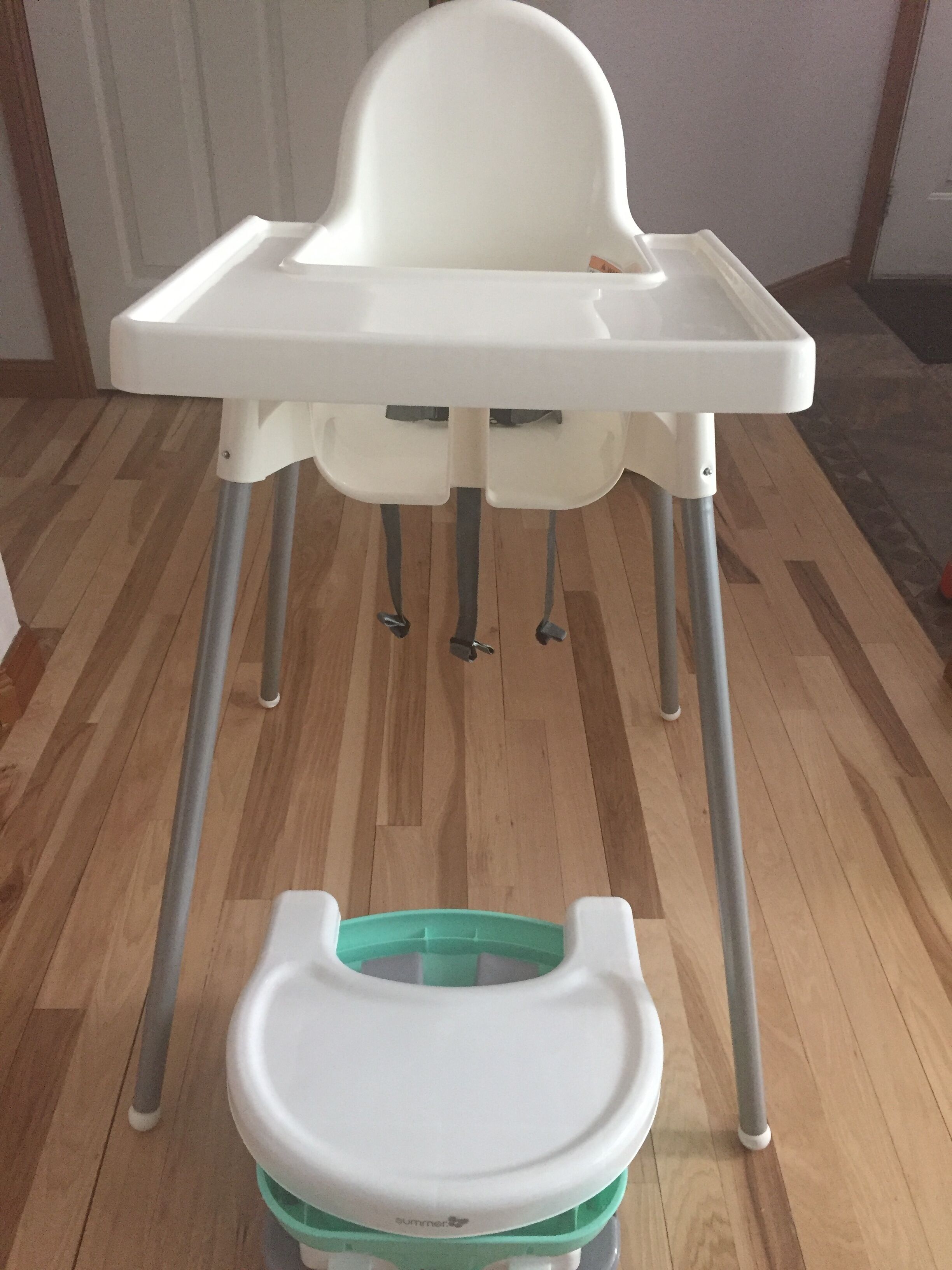 A high chair with a tray and a separate seat attached to a stand.