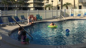 Uma área de piscina com espreguiçadeiras e um boi de piscina.