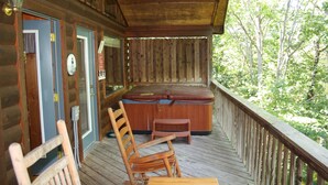 A wooden deck with a hot tub, a chair, and a table. - 2 Min to Dollywood!  5 min To Pigeon Forge! Come check us out!!! (Sevierville)