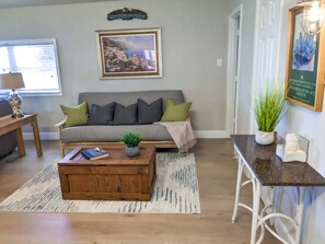 Sala de estar com sofá, mesa de centro e um quadro na parede.