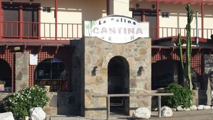Un bâtiment doté d’une arche en pierre et d’une enseigne indiquant « La Cantina ».