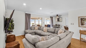 A modern living room with a sectional sofa, ceiling fans, and a view of the outdoors. - Open Water Home with lots of dolphin and manatee sightings. Boat docking. (Ellenton)