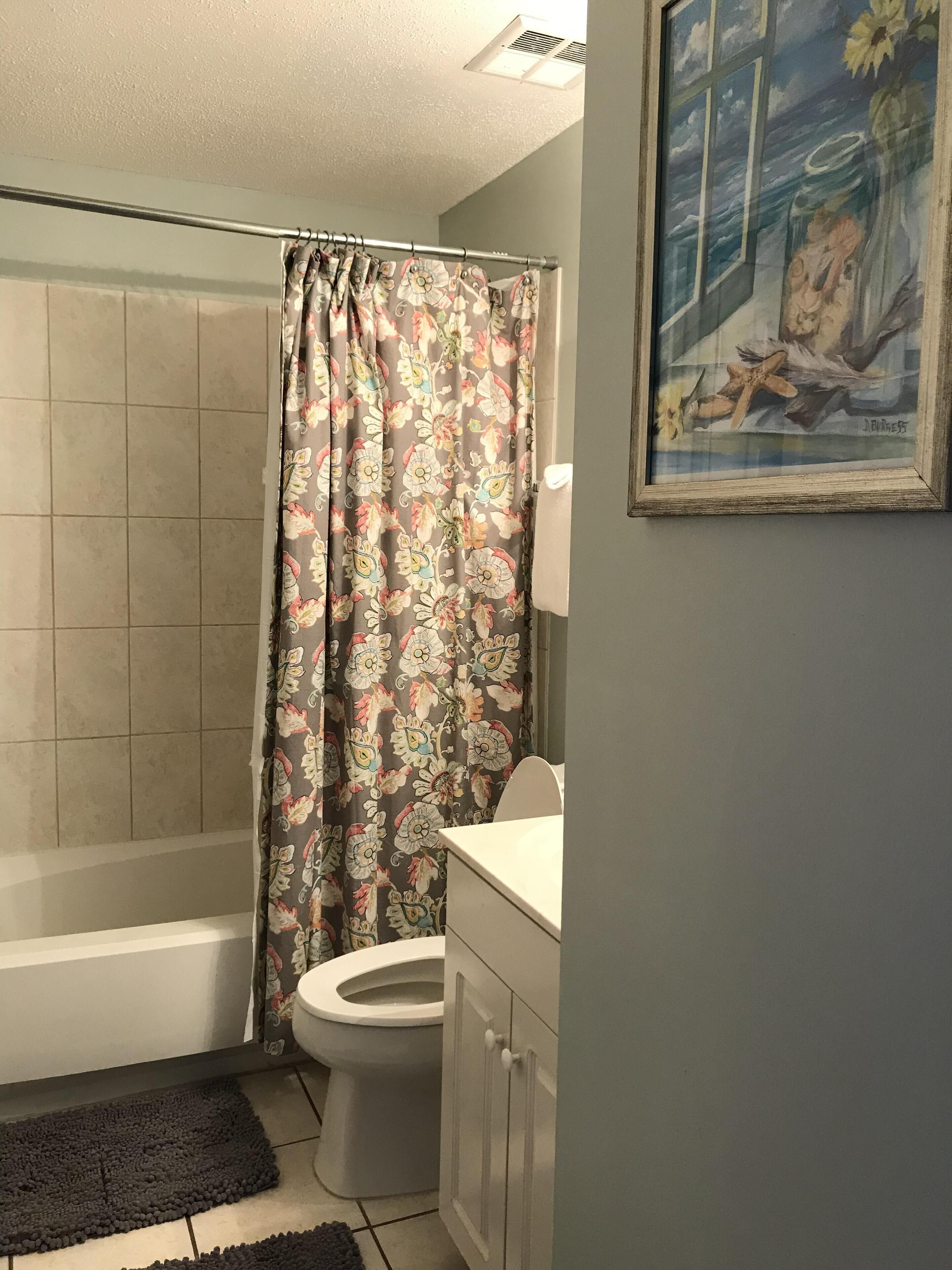 A bathroom with a shower, toilet, and sink.