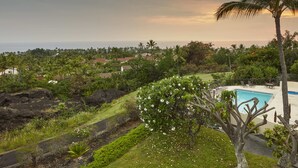 Zona de piscina con vistas al océano y vegetación circundante.