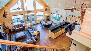 Un interior de cabaña espacioso, con comedor, cocina y zona de estar.