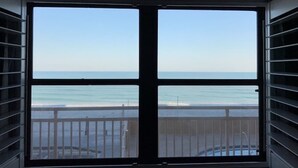 Una habitación con un amplio ventanal con vistas a la playa.
