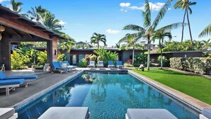 A swimming pool with lounge chairs, palm trees, and a well-maintained lawn. - Villa 6 (Kihei)