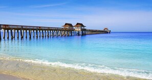A pier extending into the ocean with overwater bungalows.