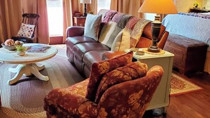 Un salon chaleureux avec un canapé en cuir, un fauteuil à motifs et une petite table sur laquelle se trouve une lampe.