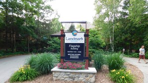 A Landmark Resort sign with a stone base and a black and white signboard, surrounded by landscaped gardens and a walking path.