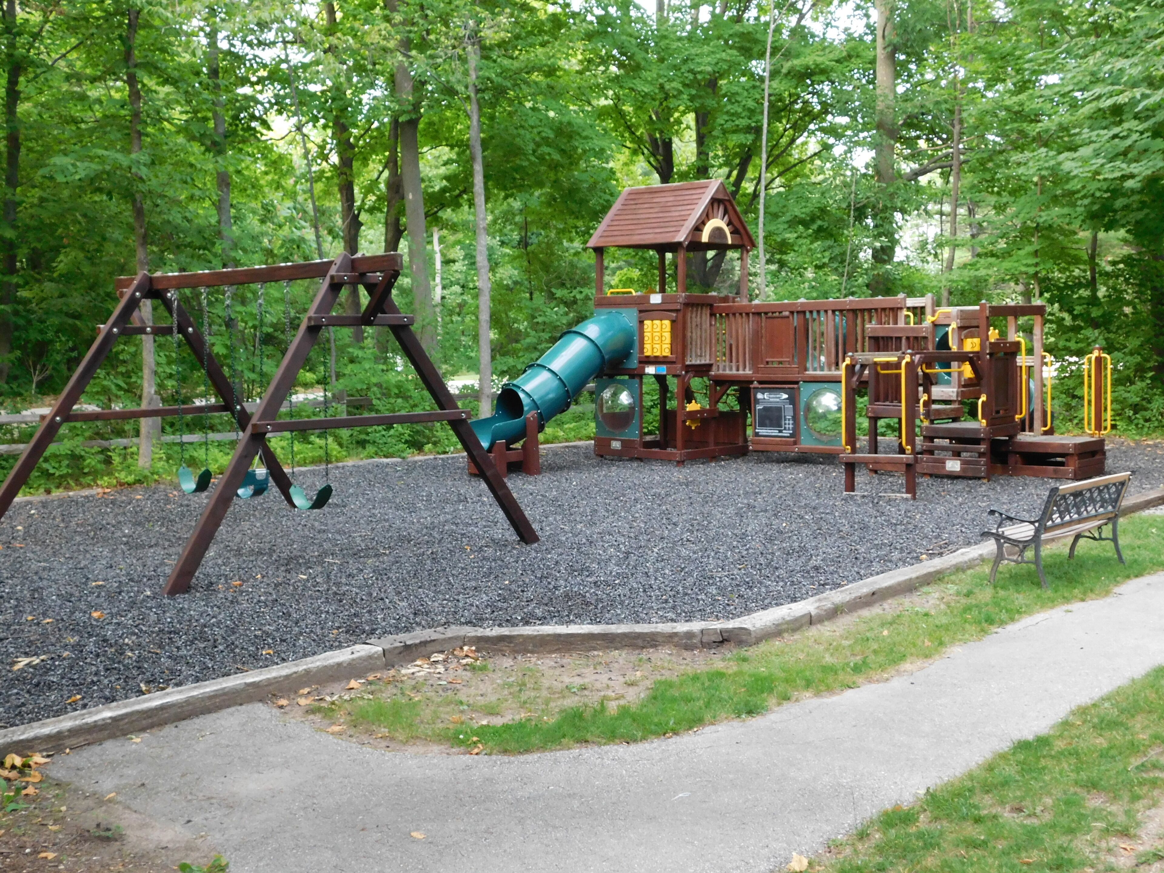 Un parque infantil con columpios, tobogán y estructuras para escalar.