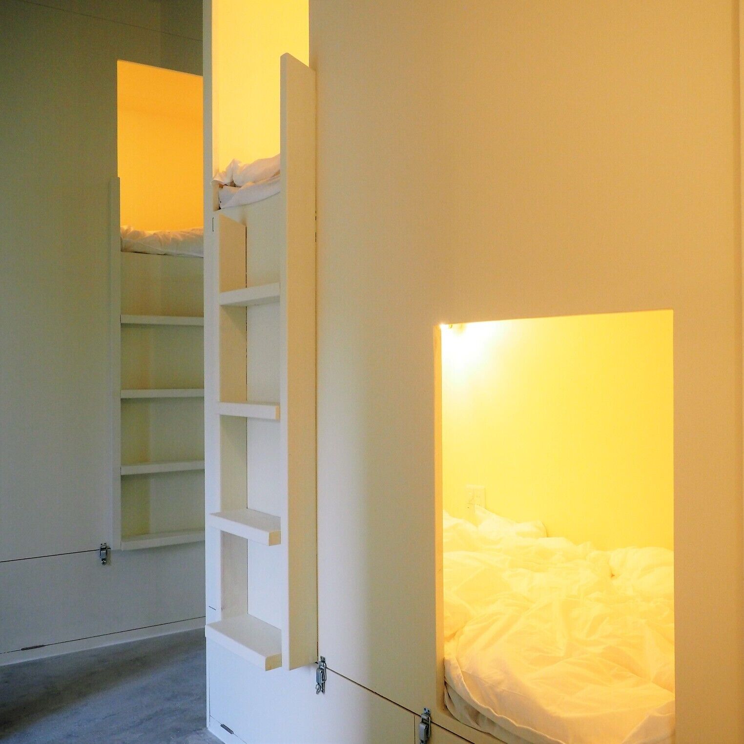 Une pièce comprenant un lit, une armoire blanche et une étagère.
