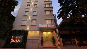 Un hôtel à plusieurs étages, avec une enseigne indiquant « Hôtel Nandana Regent » et une autre enseigne dans une langue différente.
