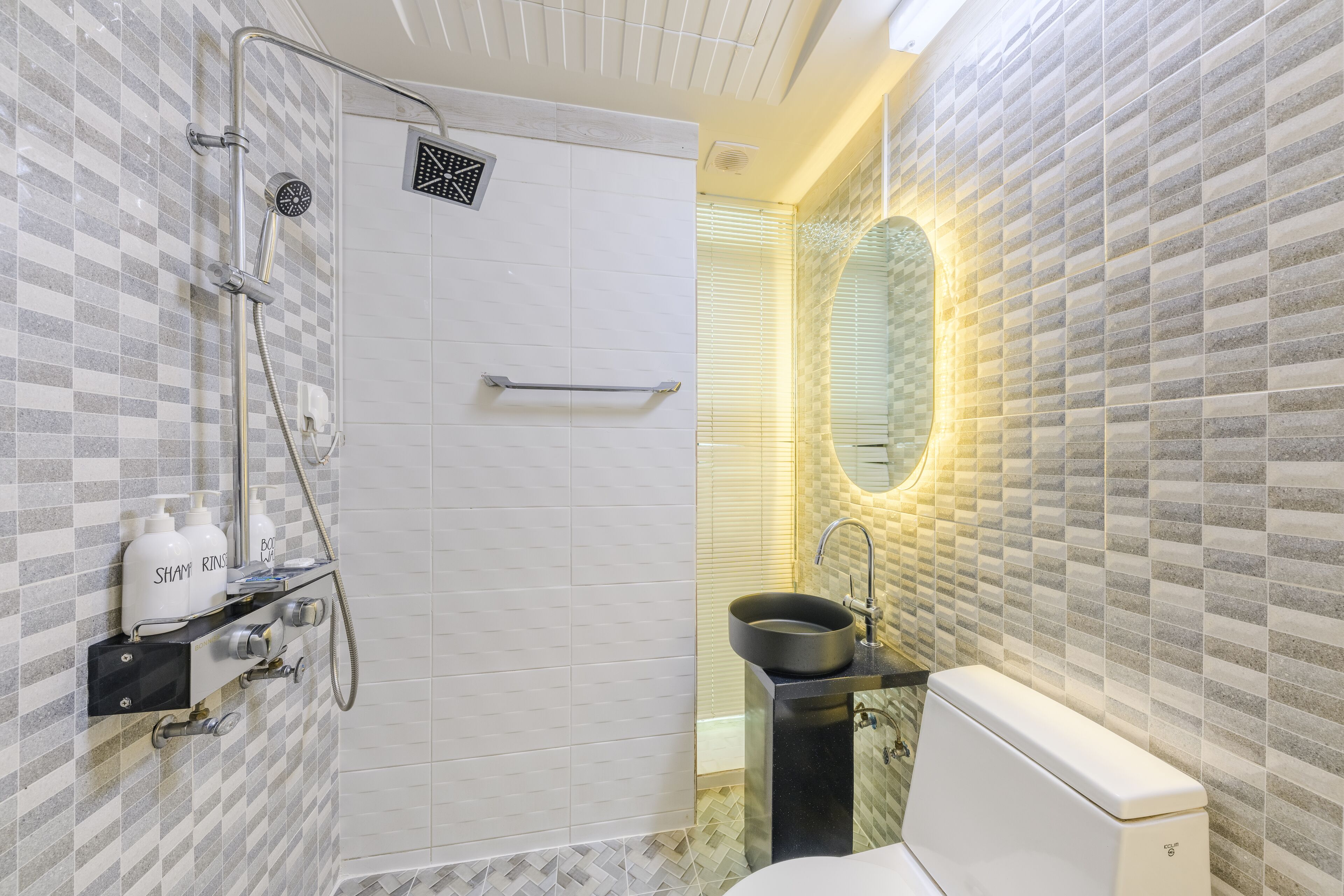 A bathroom with a shower, sink, and toilet.