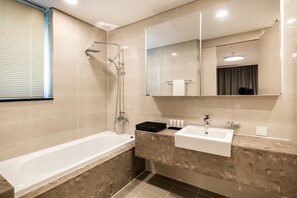 A modern bathroom with a bathtub, a sink, and a shower. - Golden Tulip Incheon Airport Hotel & Suites (Incheon)