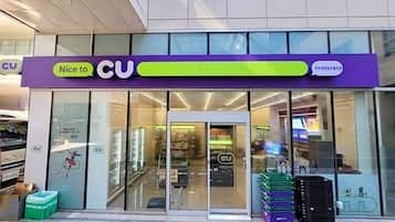 A CU store with a purple and green sign, glass doors, and a visible interior with shelves and products.