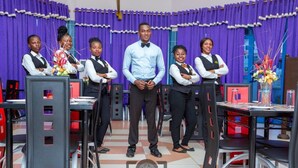 A group of people standing in a room with purple curtains and a tiled floor. - Cofkans Hotel (Obuasi)