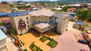 A hotel with a central courtyard, multiple floors, and a distinctive facade. - Cofkans Hotel (Obuasi)