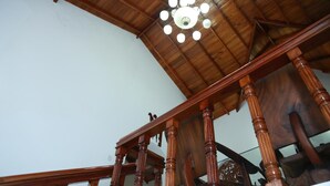 Een houten trap met een houten plafond en een kroonluchter.