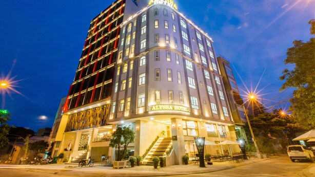 A multi-story hotel with a prominent sign at the top, a well-lit entrance, and a staircase leading to the lobby. - Alyssa Da Nang Hotel (Da Nang)