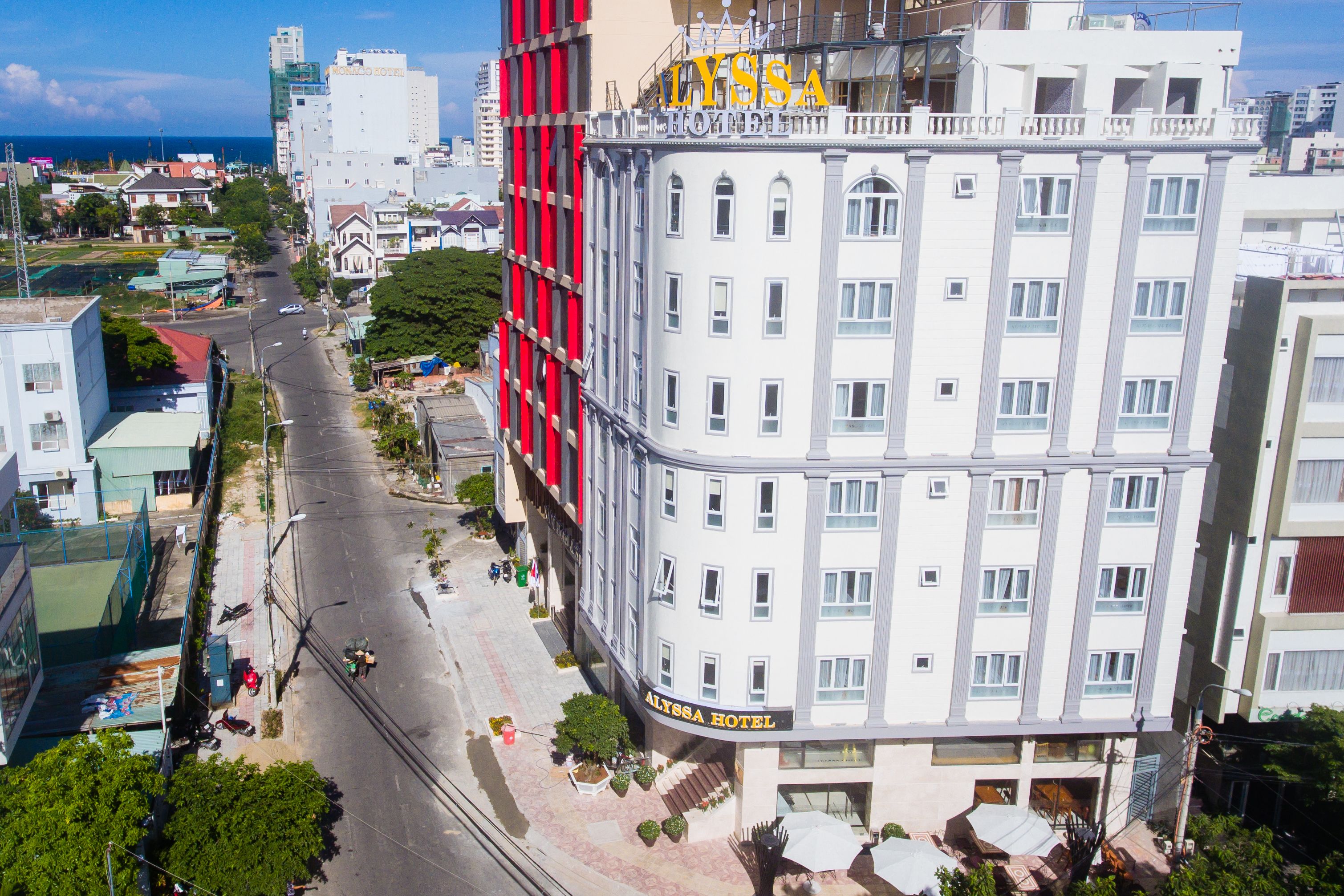 A hotel with a white facade, balconies, and a sign reading "ALISSA HOTEL".