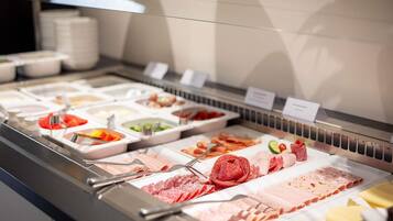 A buffet with various food items including meats, cheeses, and vegetables.