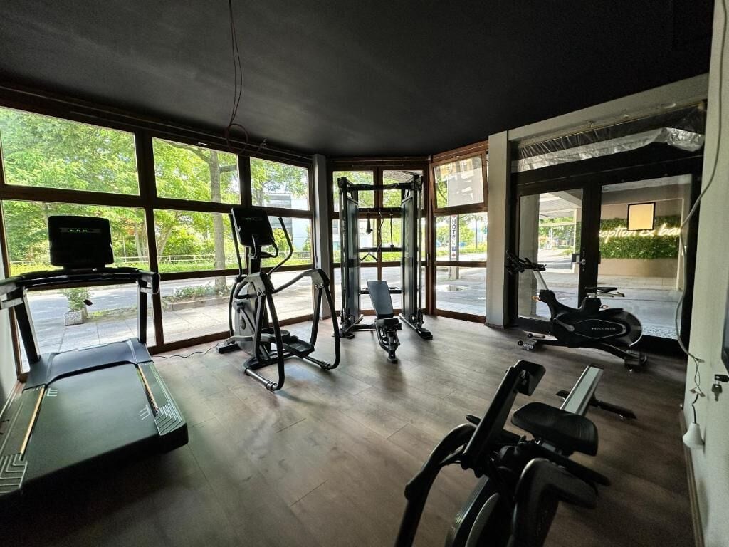 A gym with a treadmill, elliptical, and stationary bikes.