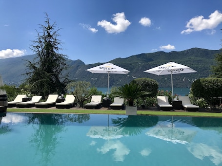 Una piscina al aire libre de temporada, sombrillas