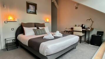 Une chambre moderne avec un grand lit, des lampes de chevet, un bureau et une chaise.