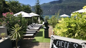 Een zwembadgedeelte met ligbedden, parasols en een bord met de tekst 'ACCES PISCINE'.