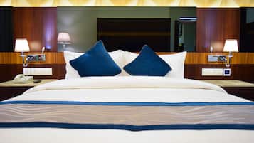 Relax in a stylish room with a large bed, wooden paneling, and a geometric ceiling.