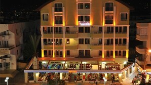 A multi-story hotel with a central atrium, balconies, and a ground-level restaurant. - Mitos App & Hotel (Alanya)