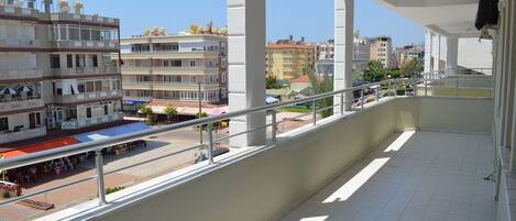 Un balcón con vistas a un paisaje urbano, con edificios de varios pisos y una calle abajo.