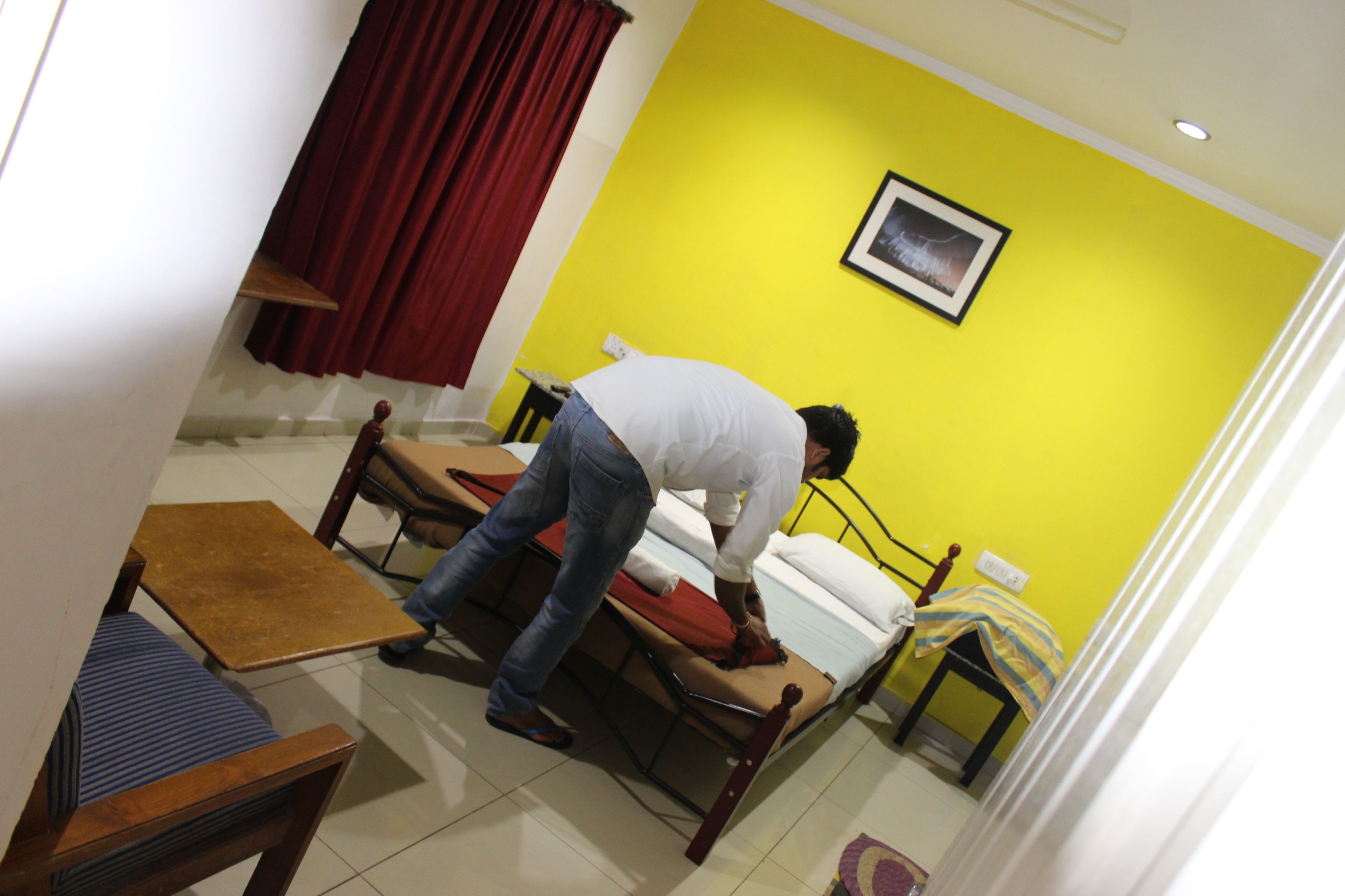 A room with a bed, a small table, and a chair.