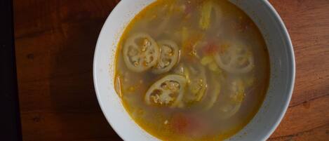 A bowl of soup on a wooden table.