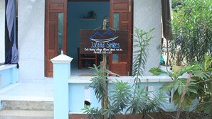 A wooden door with a signboard for 'Island Smiles' in front of a building. - Island Smiles Homestay (Da Nang)