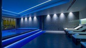 A modern spa with a blue-lit pool, exercise equipment, and lounge areas. - Messier 53 Hotel Yerevan (Yerevan)
