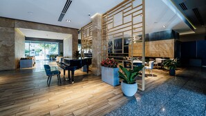 A spacious lobby with a grand piano, seating area, and a decorative wall with a geometric pattern. - Messier 53 Hotel Yerevan (Yerevan)
